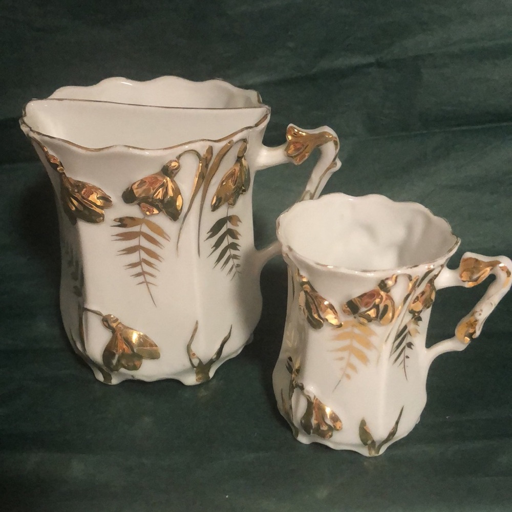 A beautiful little hand painted cup paired with an antique mustache cup.